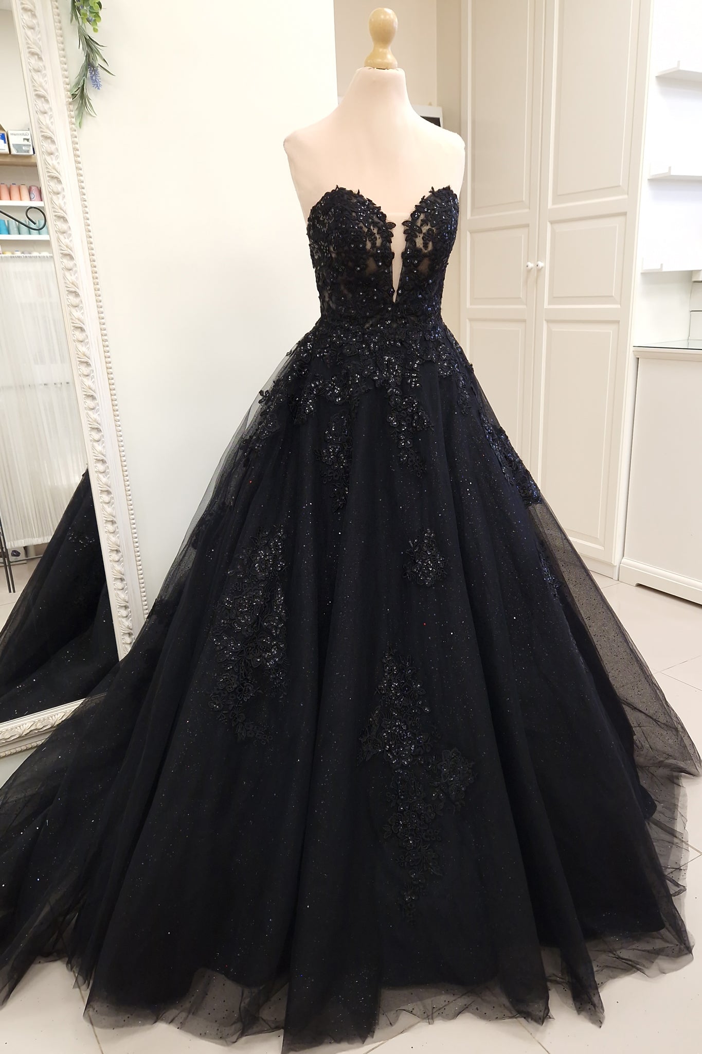 Black wedding dress in ball gown silhouette with deep plunging sweetheart neckline, detachable off-shoulder straps and semi-sheer corset bodice.