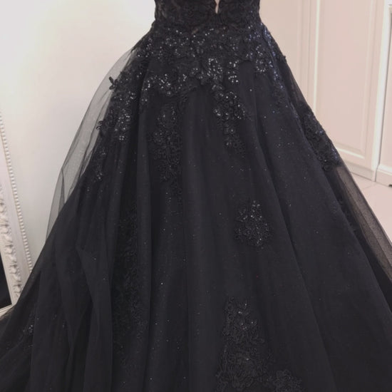 Black wedding dress in ball gown silhouette with deep plunging sweetheart neckline, detachable off-shoulder straps and semi-sheer corset bodice.