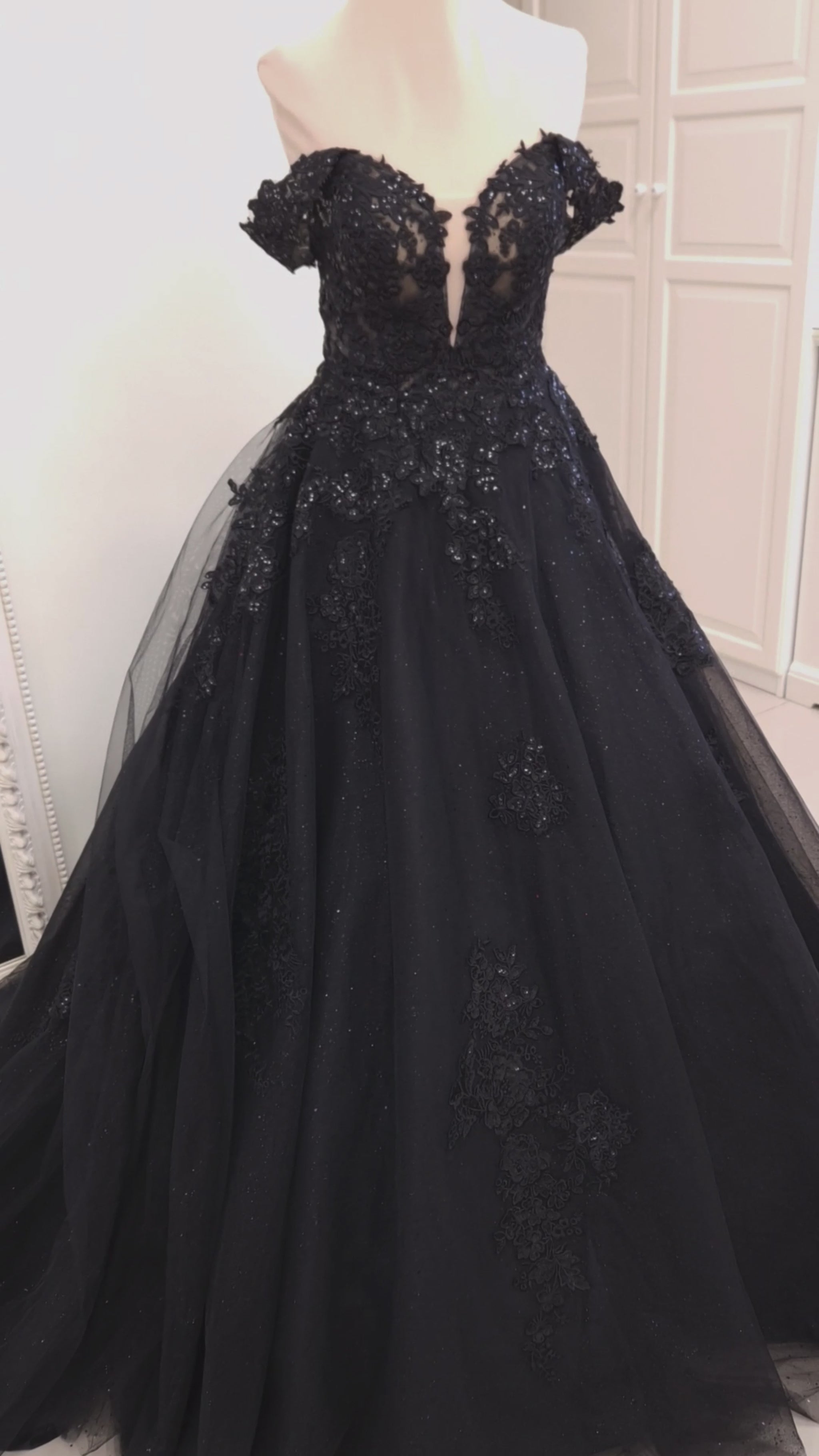 Black wedding dress in ball gown silhouette with deep plunging sweetheart neckline, detachable off-shoulder straps and semi-sheer corset bodice.