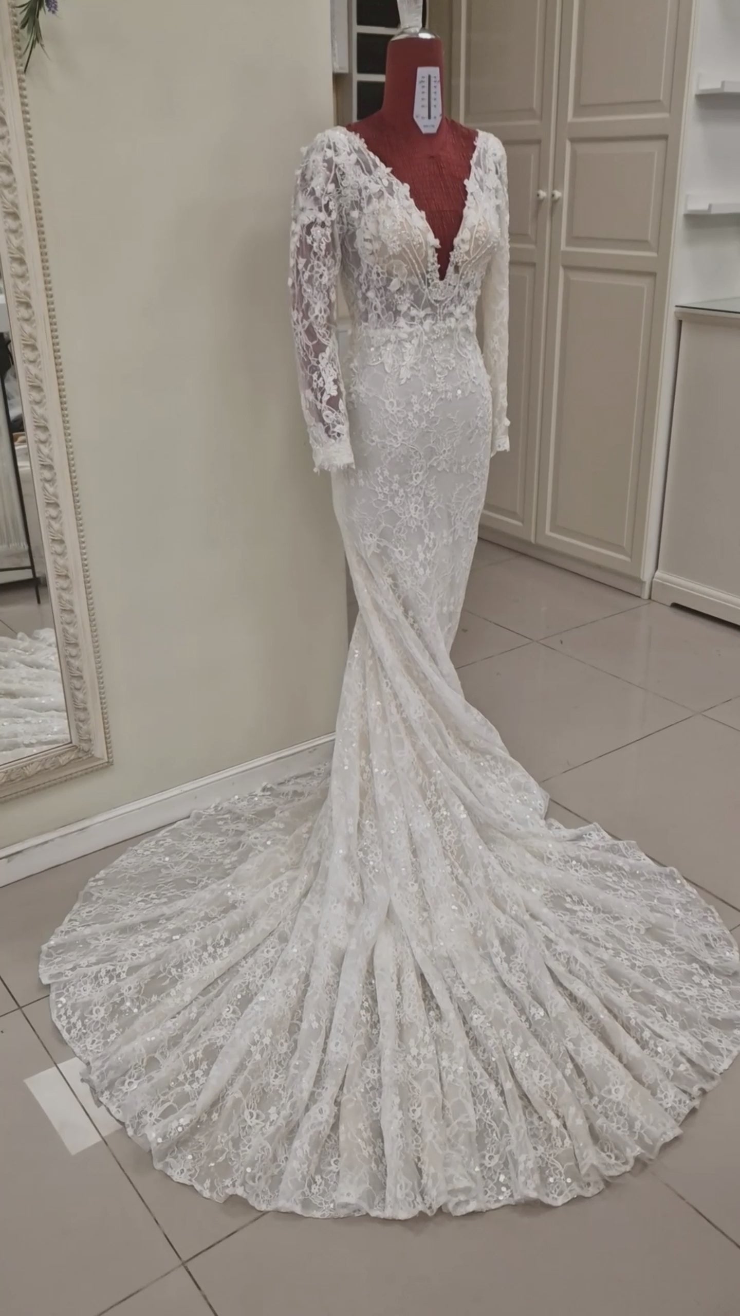 Lace wedding dress from our 2024 couture collection. The gown has a figure hugging trumpet silhouette, long sleeves, deep plunging V-neckline and V-back and lots of beading and sparkle.